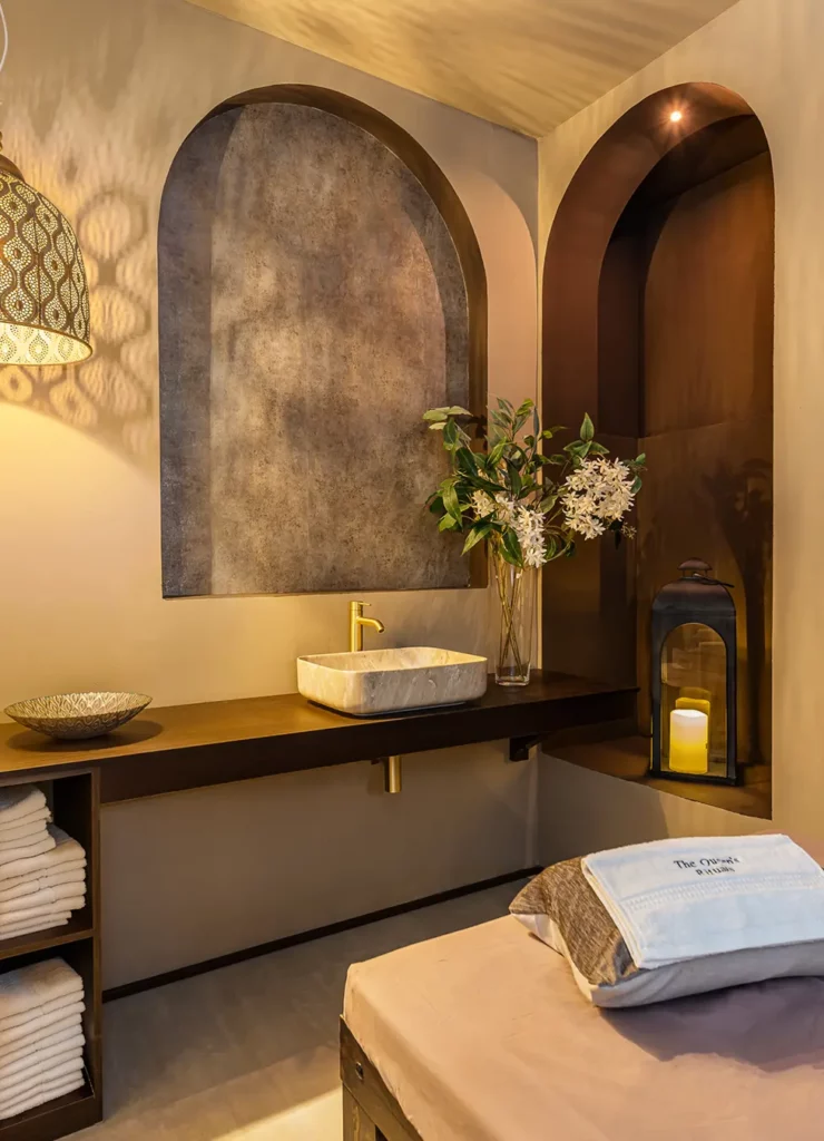 Cabina individual con camilla, lavamanos y farol de velas en The Queen's Rituals