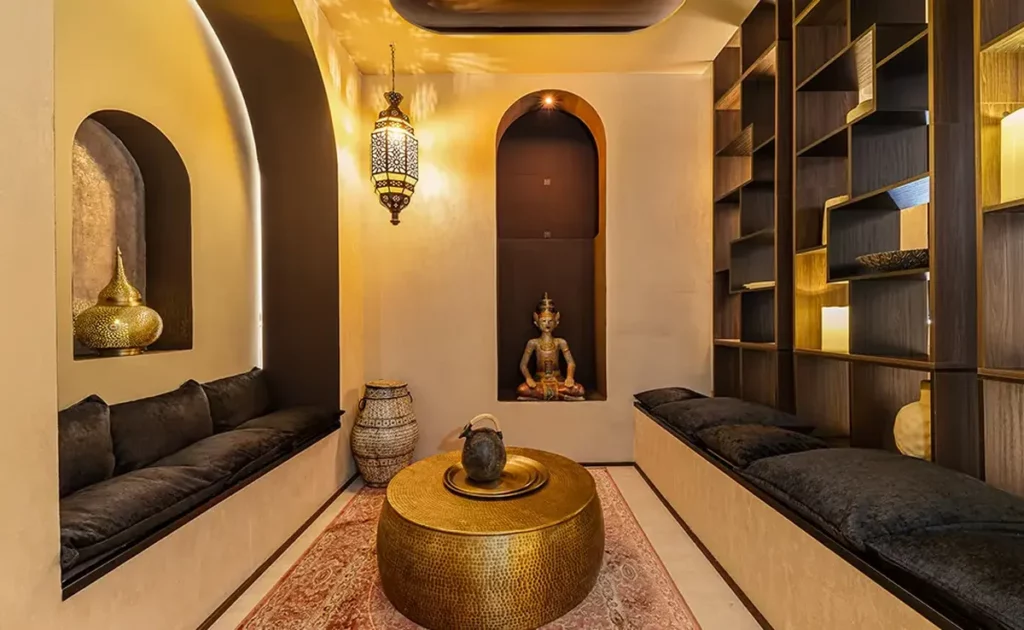 Relaxation area at The Queen's Rituals day spa in Madrid with arched niches, lanterns and cushioned benches
