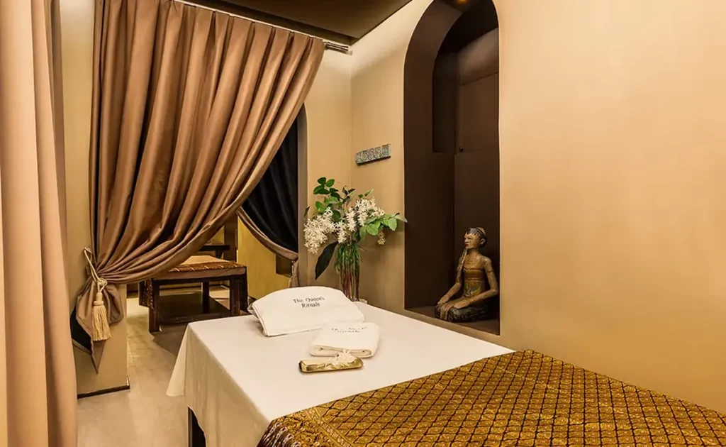 Private treatment room at The Queen's Rituals in Madrid with warm light, curtain and a prepared massage bed